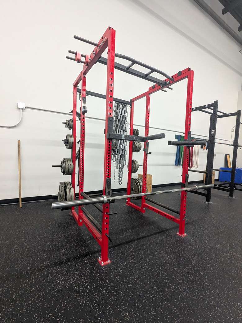 A power rack and loaded barbell on the Better Forever training floor